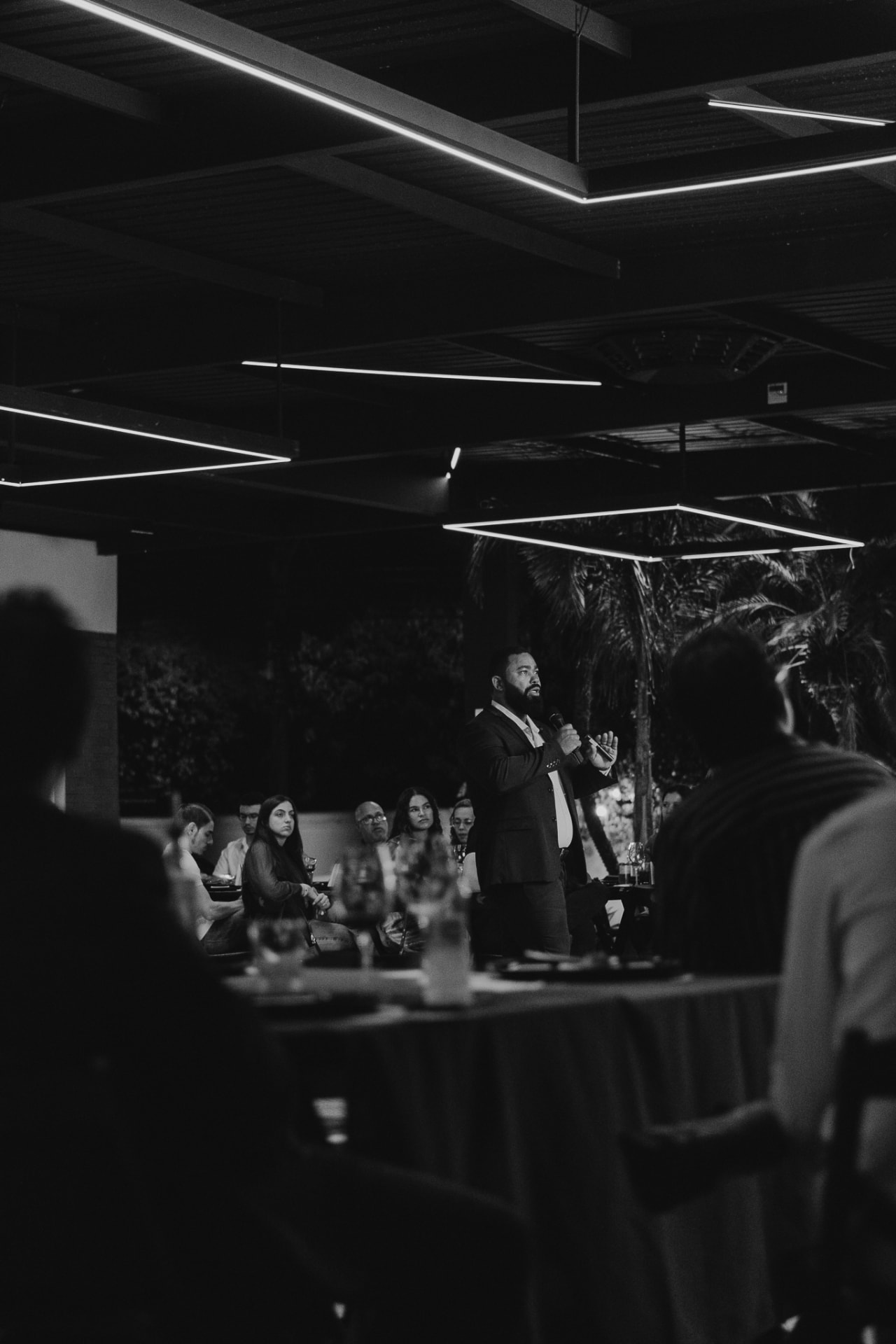 Apresentação ao microfone para a plateia em um encontro noturno do Prime Club