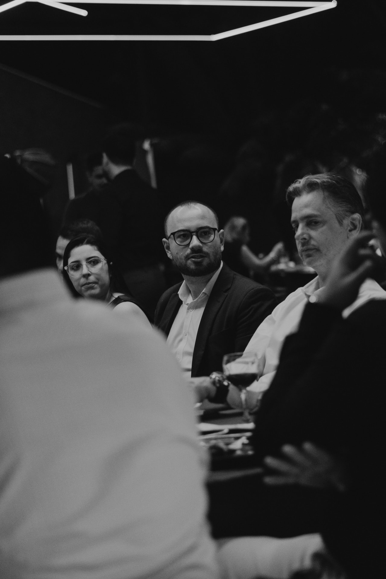 Três convidados conversando à mesa durante um encontro do Prime Club