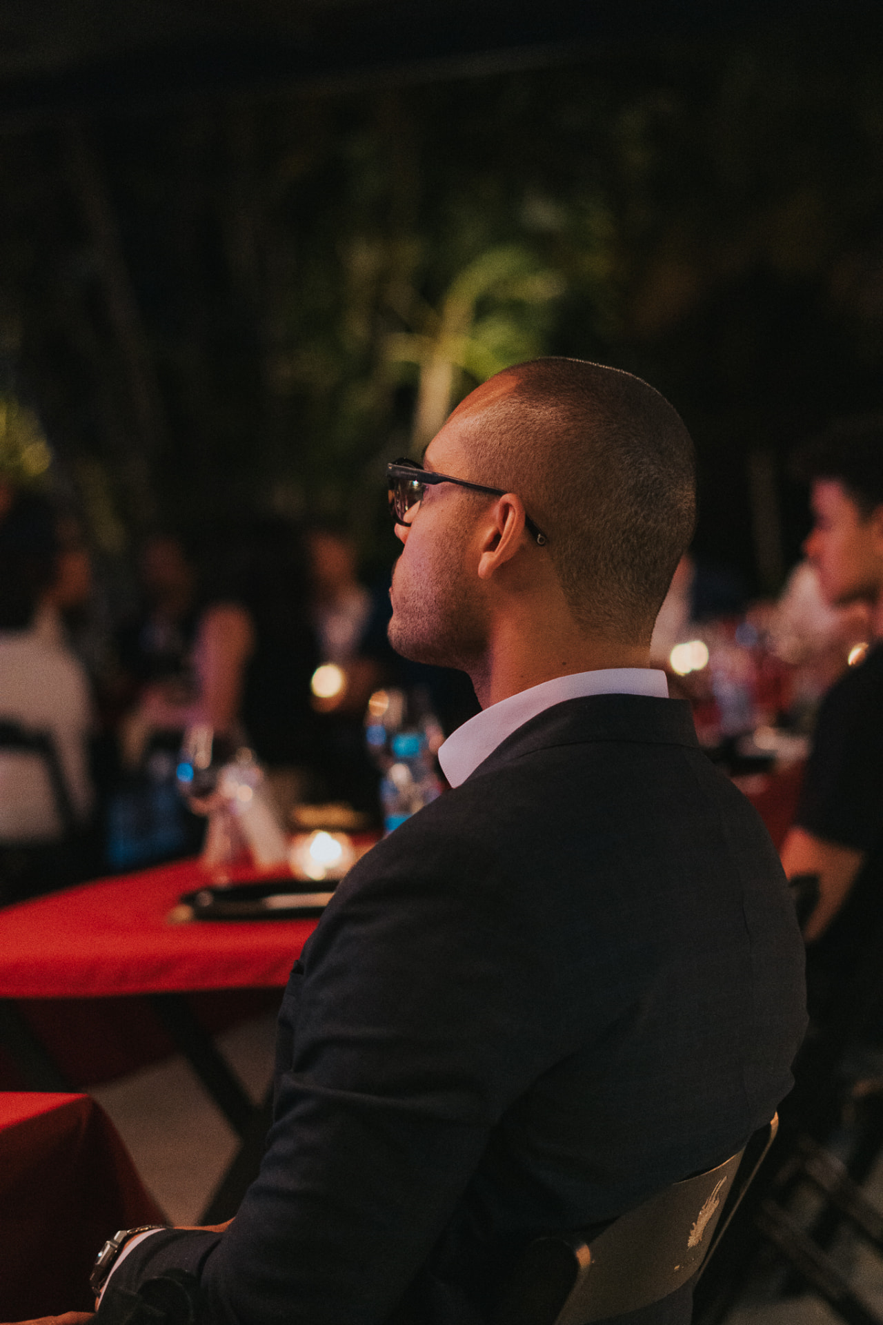 Convidado acompanhando uma apresentação à mesa, em um encontro ao ar livre do Prime Club