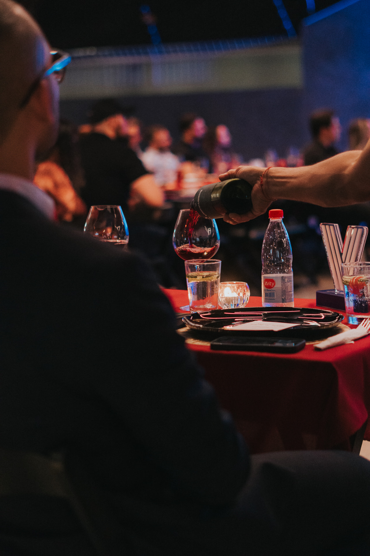 Garçom servindo vinho a um convidado durante um jantar do Prime Club