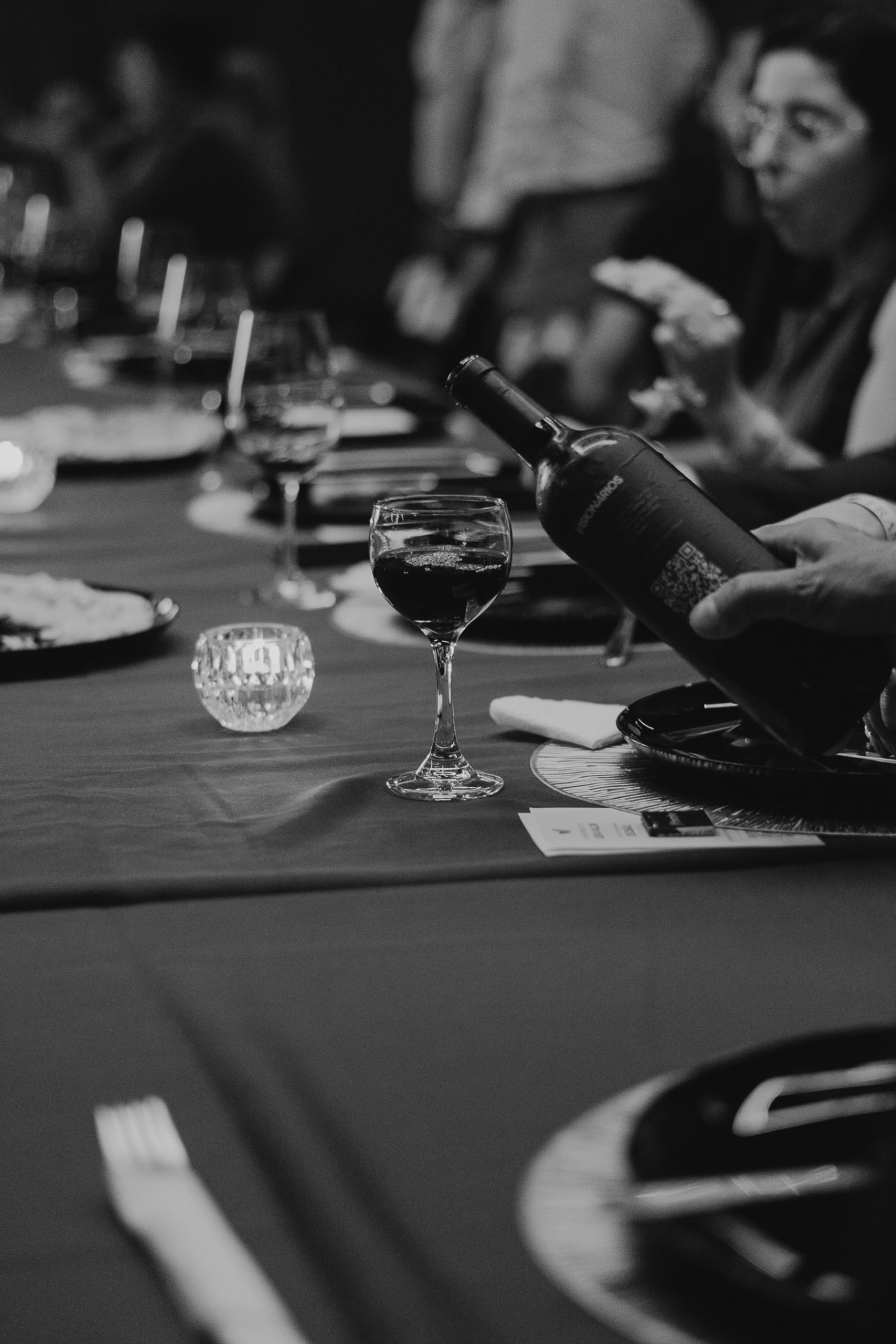 Vinho sendo servido em taças em uma mesa posta durante um jantar do Prime Club